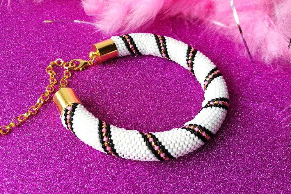 Tubular peyote bracelet pattern with stripe in white, black, pink and gold.